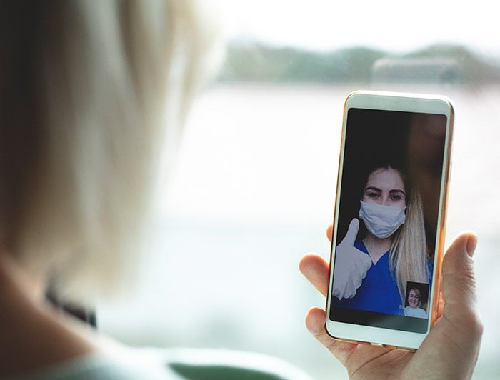 Patient using technology to interact with nurse during COVID-19 pandemic