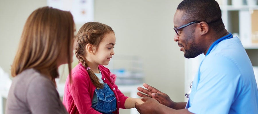 pediatric nurse looking at child's wrist