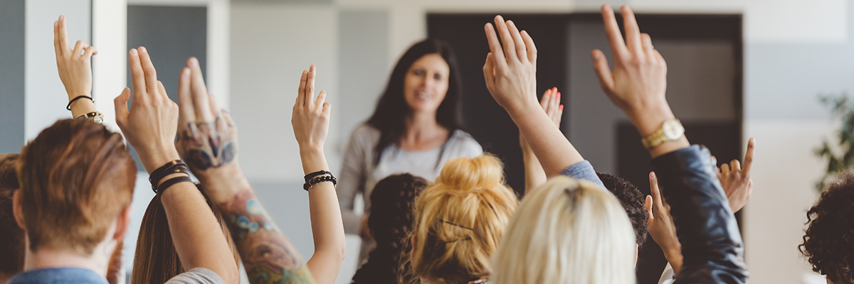 People in classroom learning with an instructor in front. 