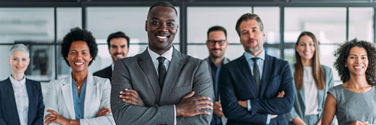 Diverse executives stand side by side, arms crossed and smiling